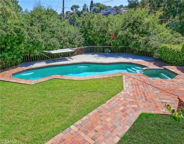 view of pool with an in ground hot tub, a yard, and a patio