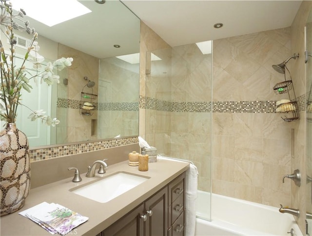 bathroom with vanity and tiled shower / bath combo