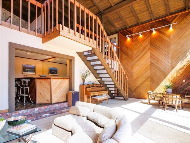 living room featuring wood walls, wooden ceiling, rail lighting, and high vaulted ceiling