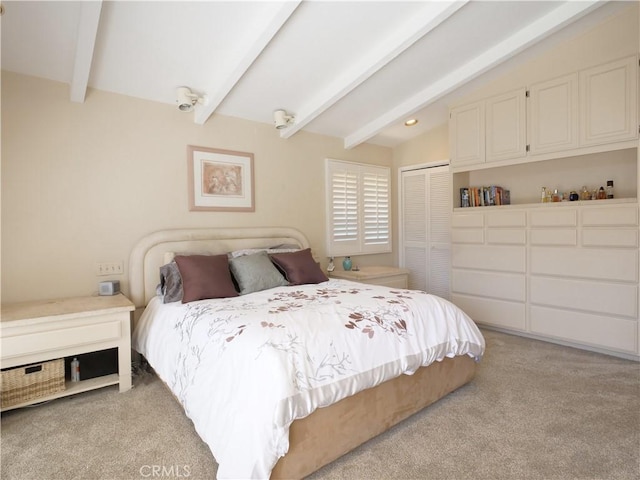 bedroom with lofted ceiling with beams, light colored carpet, and a closet