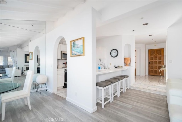 42 Camino De Flores Unit 60, Avalon, CA 90704 - hallway with arched walkways, baseboards, and light wood-style floors