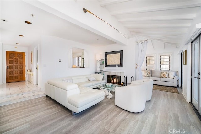 42 Camino De Flores Unit 60, Avalon, CA 90704 - living area featuring lofted ceiling with beams, a tiled fireplace, and light wood-style floors