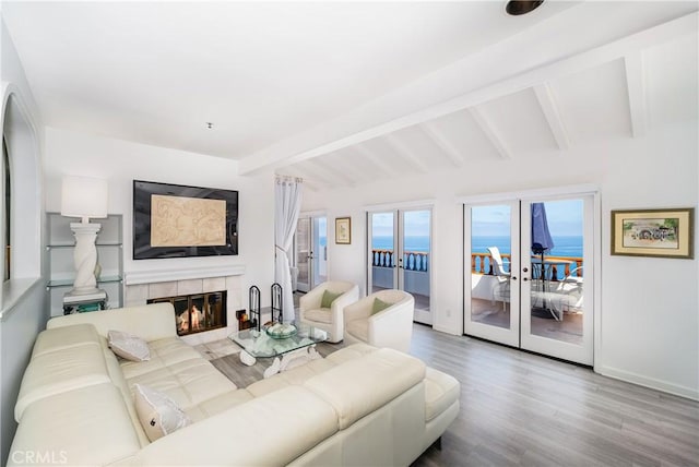 42 Camino De Flores Unit 60, Avalon, CA 90704 - living area with wood finished floors, a tile fireplace, vaulted ceiling with beams, baseboards, and french doors
