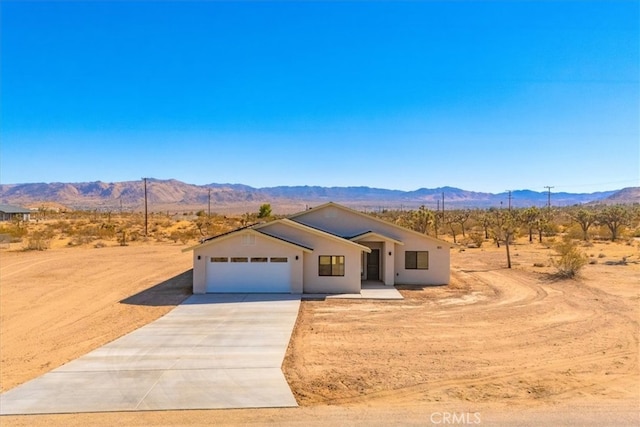 view of front of home with a mountain view and a garage