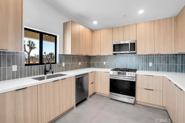 kitchen with stainless steel appliances, backsplash, light brown cabinetry, and sink