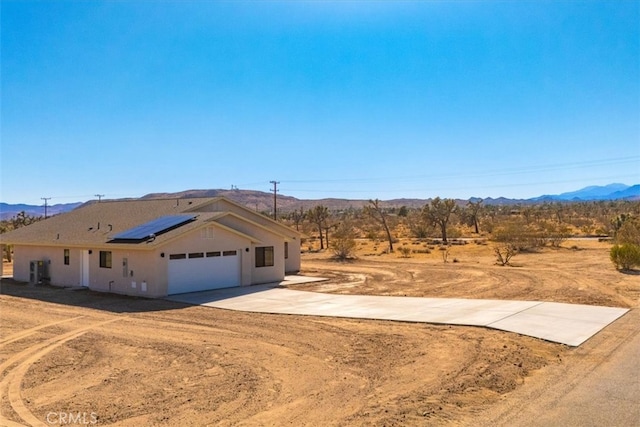 view of front of home featuring a mountain view, a garage, and solar panels