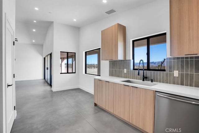 kitchen with decorative backsplash, stainless steel dishwasher, sink, and plenty of natural light