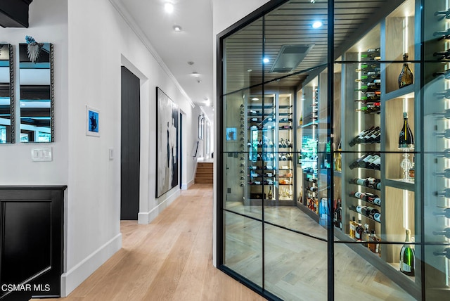 wine cellar featuring ornamental molding and hardwood / wood-style floors