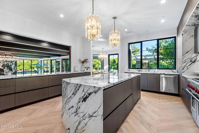 kitchen featuring dishwasher, light parquet floors, decorative light fixtures, a spacious island, and a notable chandelier