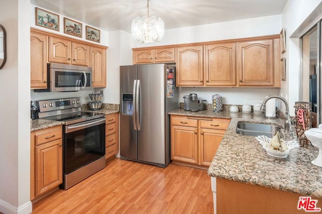 kitchen featuring sink, decorative light fixtures, light hardwood / wood-style floors, stainless steel appliances, and a chandelier