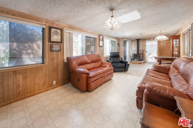 living room with a wood stove, a wealth of natural light, and wood walls