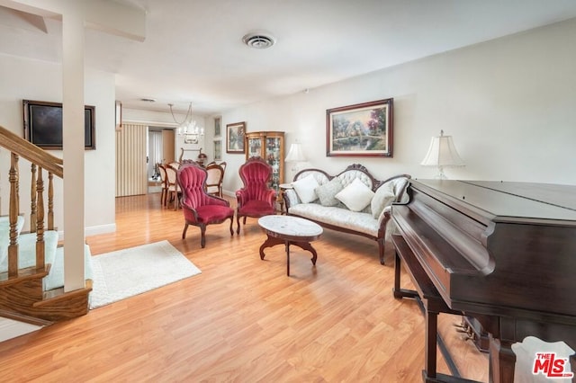 living room with a chandelier and light wood-type flooring