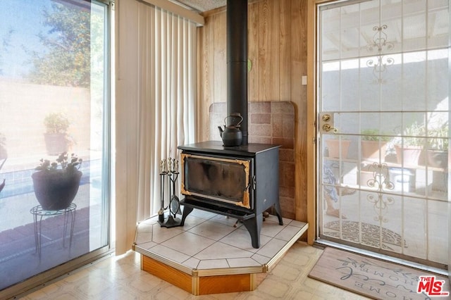 interior details featuring a wood stove and wood walls