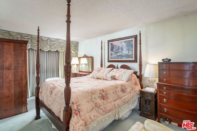 bedroom featuring light colored carpet and a textured ceiling