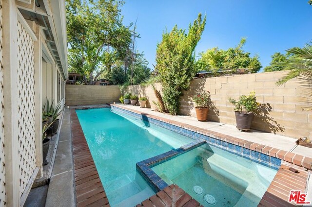 view of pool featuring an in ground hot tub