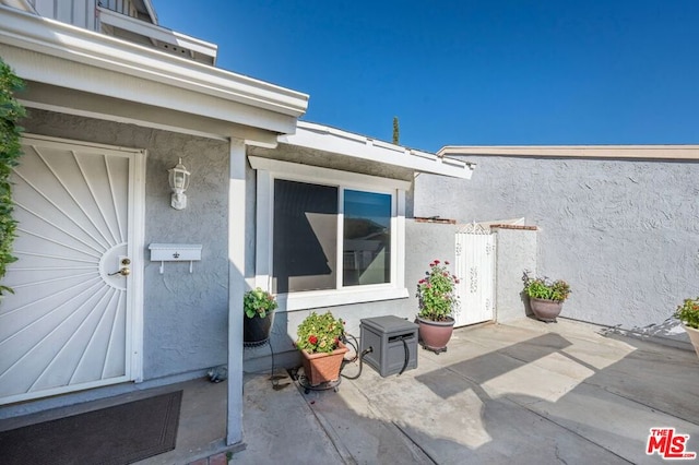 view of exterior entry with a patio