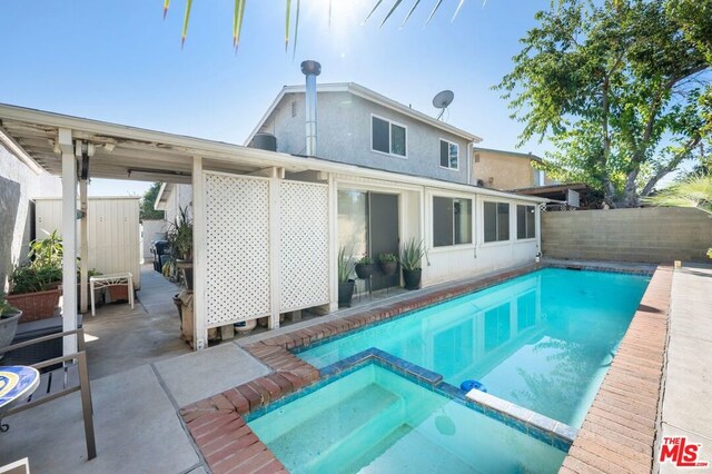 view of swimming pool with an in ground hot tub