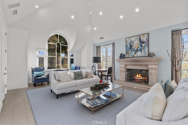 living room featuring light hardwood / wood-style floors and high vaulted ceiling