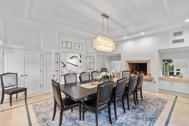 dining space featuring a high ceiling, a raised ceiling, and a notable chandelier