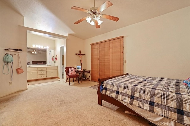 bedroom with connected bathroom, lofted ceiling, ceiling fan, and light colored carpet