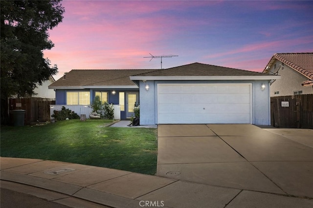 ranch-style house with a garage and a yard