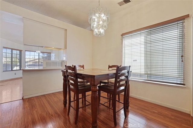 dining space featuring hardwood / wood-style floors and a chandelier