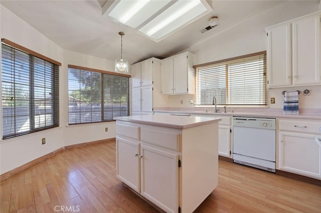 kitchen featuring white cabinets, white dishwasher, and decorative light fixtures