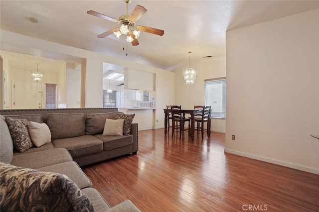 living room with wood-type flooring and ceiling fan with notable chandelier