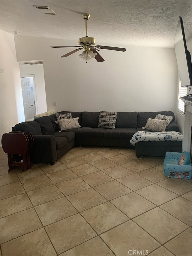 living room with a textured ceiling and ceiling fan