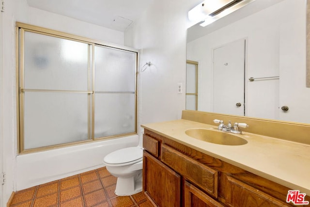 full bathroom with combined bath / shower with glass door, vanity, and toilet