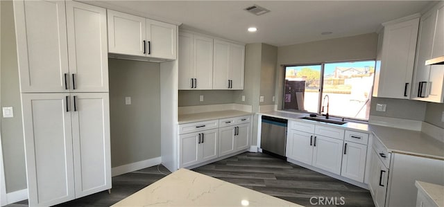 kitchen with dark wood-type flooring, white cabinets, sink, and stainless steel dishwasher