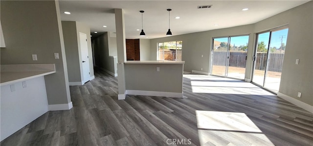 kitchen featuring hanging light fixtures and dark wood-type flooring