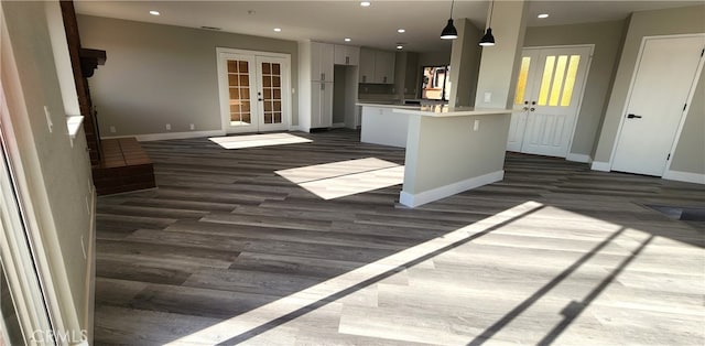 kitchen with white cabinets, hanging light fixtures, french doors, a center island, and dark hardwood / wood-style flooring