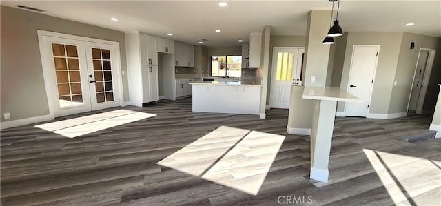 kitchen featuring french doors, dark hardwood / wood-style floors, sink, white cabinetry, and hanging light fixtures