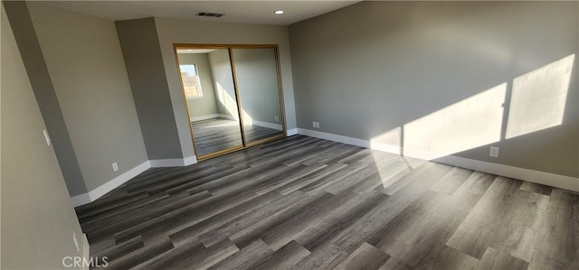 interior space with dark wood-type flooring and a closet