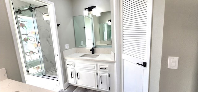 bathroom with a wealth of natural light, a shower with shower door, and vanity