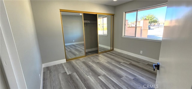 unfurnished bedroom with a closet and hardwood / wood-style floors