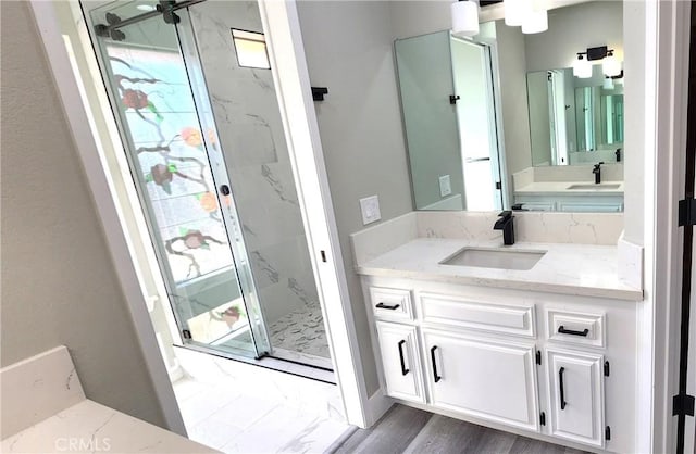 full bath featuring a healthy amount of sunlight, a marble finish shower, vanity, and wood finished floors