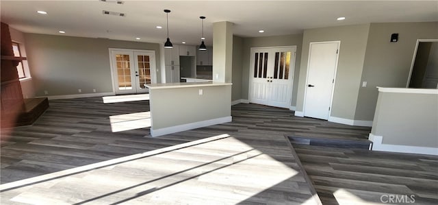 kitchen with french doors, hanging light fixtures, dark wood-type flooring, and kitchen peninsula