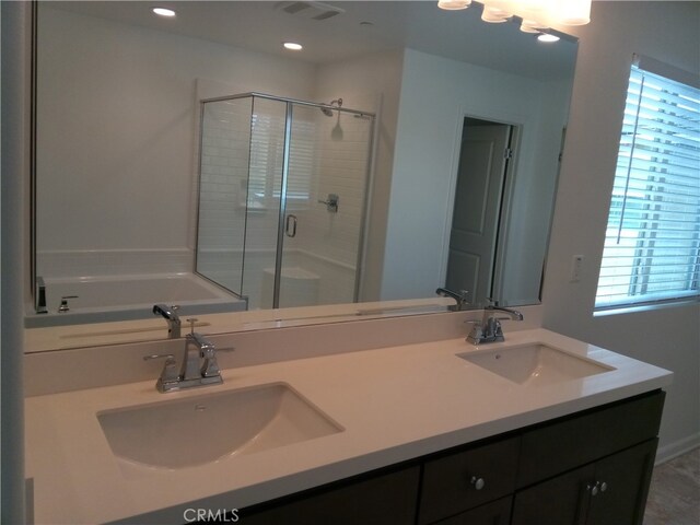 bathroom featuring vanity, plus walk in shower, and plenty of natural light