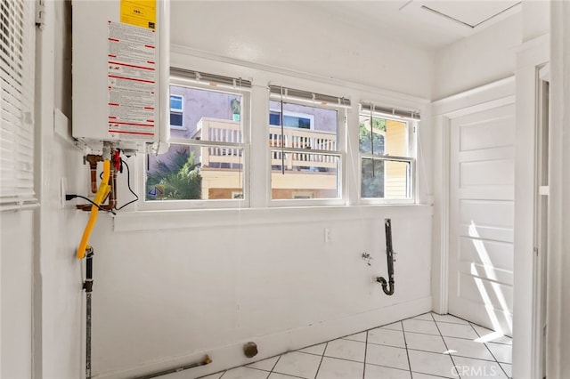 washroom featuring light tile patterned flooring and water heater