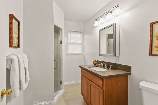 bathroom with a shower with door, vanity, and toilet