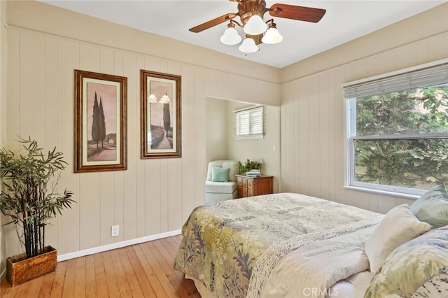 bedroom featuring multiple windows, light hardwood / wood-style floors, and ceiling fan