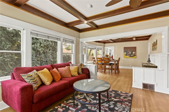 living room featuring light hardwood / wood-style floors, beam ceiling, and ceiling fan