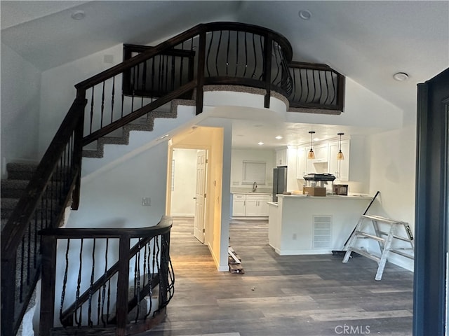 stairway with sink and hardwood / wood-style floors