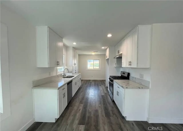 kitchen with stainless steel appliances, sink, dark hardwood / wood-style flooring, and white cabinetry