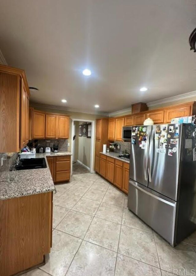 kitchen with decorative backsplash, crown molding, sink, and appliances with stainless steel finishes