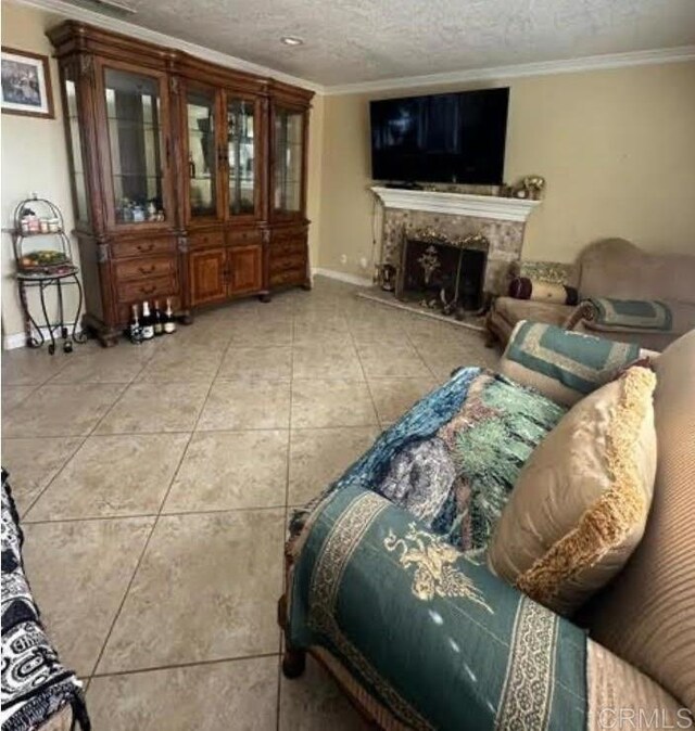 tiled living room with a textured ceiling, crown molding, and a fireplace