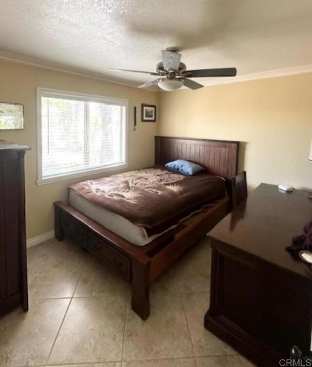 tiled bedroom featuring a textured ceiling, ceiling fan, and ornamental molding