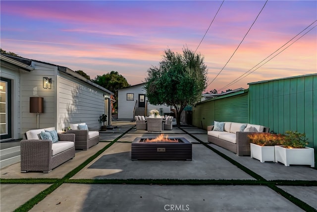 patio terrace at dusk with an outdoor living space with a fire pit